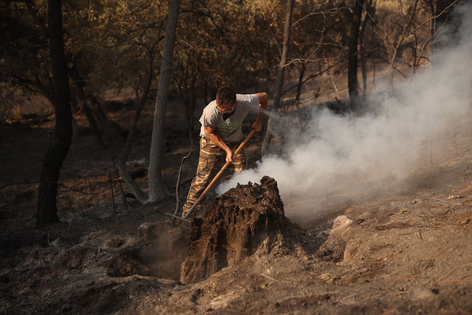 Una hombre trata de apagar lo que queda de fuego en el incendio forestal a las afueras de Casavieja