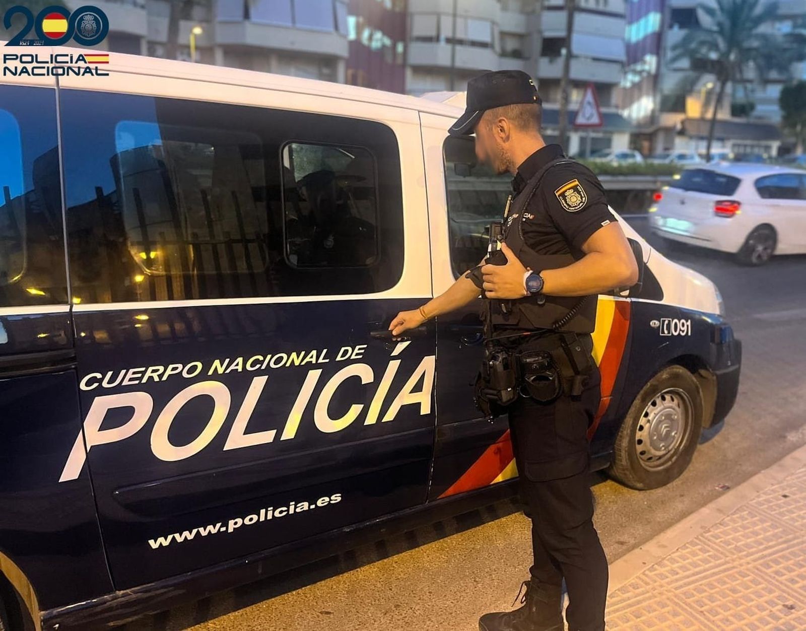 Un agente de la Policía Nacional junto a un furgón policial