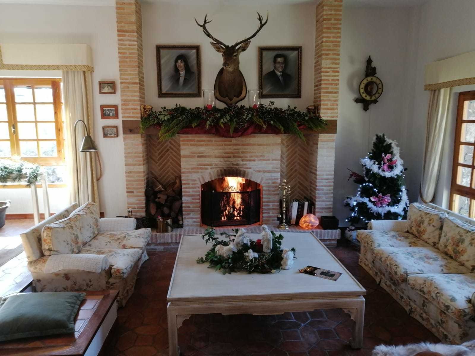 Aquí tenemos una casa rústica clásica, con su chimenea, su cabeza de ciervo y sus sofás cuidadosamente tapizados.
