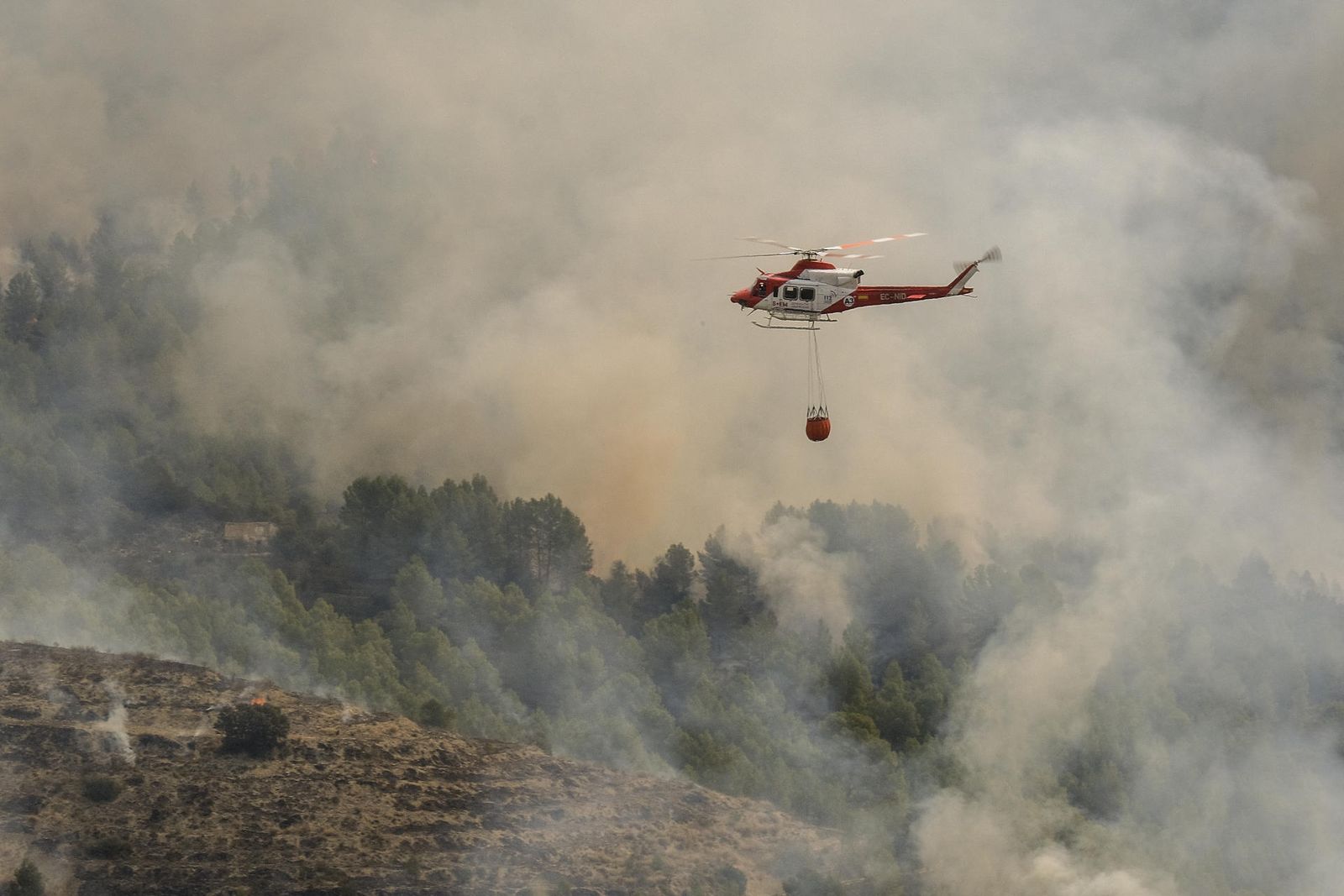 Un helicóptero trabaja en la extinción del incendio forestal de Tárbena, Alicante