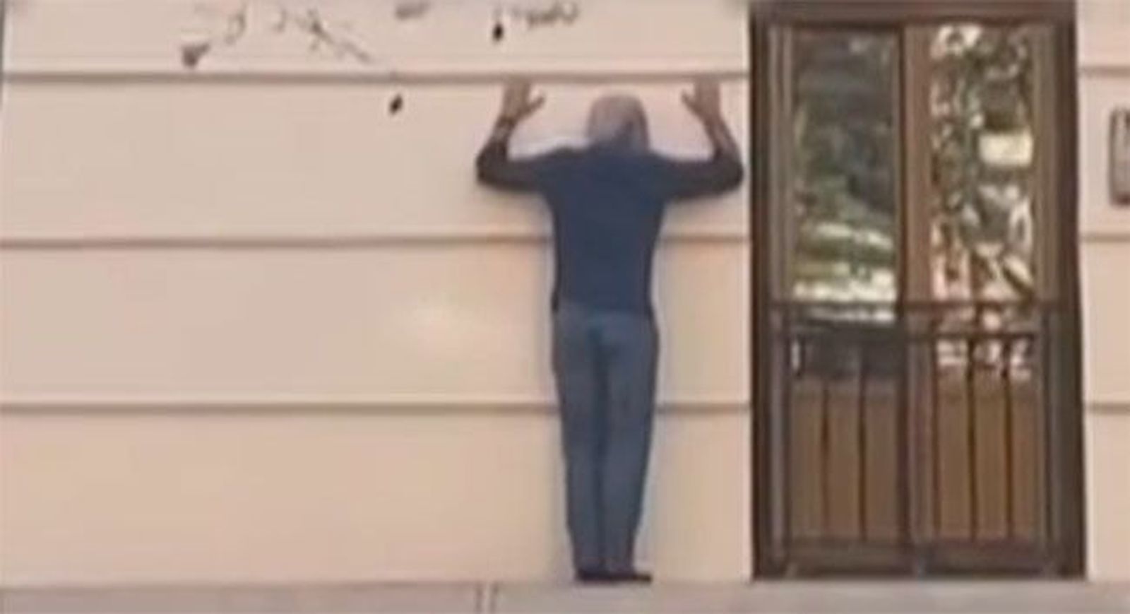 Se hace un 'spiderman' imprudente en plena calle Princesa para entrar en su casa