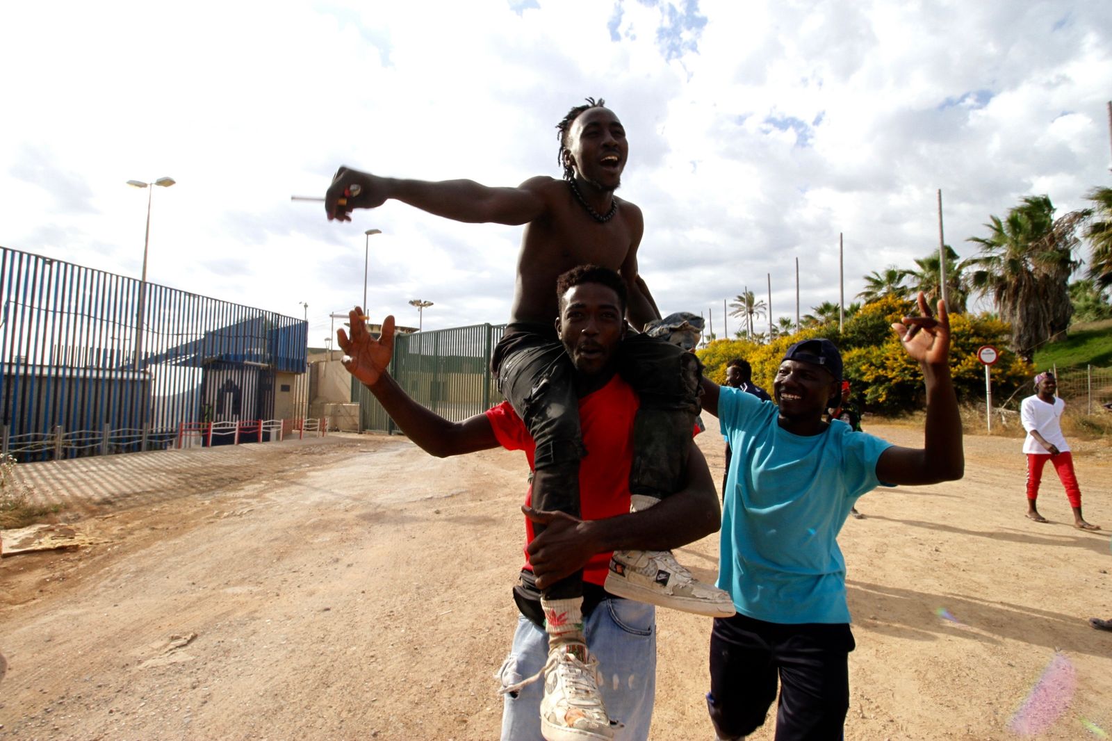 Varios migrantes se dirigen al Centro Temporal de Inmigrantes (CETI), mientras celebran el salto de la valla de Melilla, a 24 de junio de 2022, en Melilla