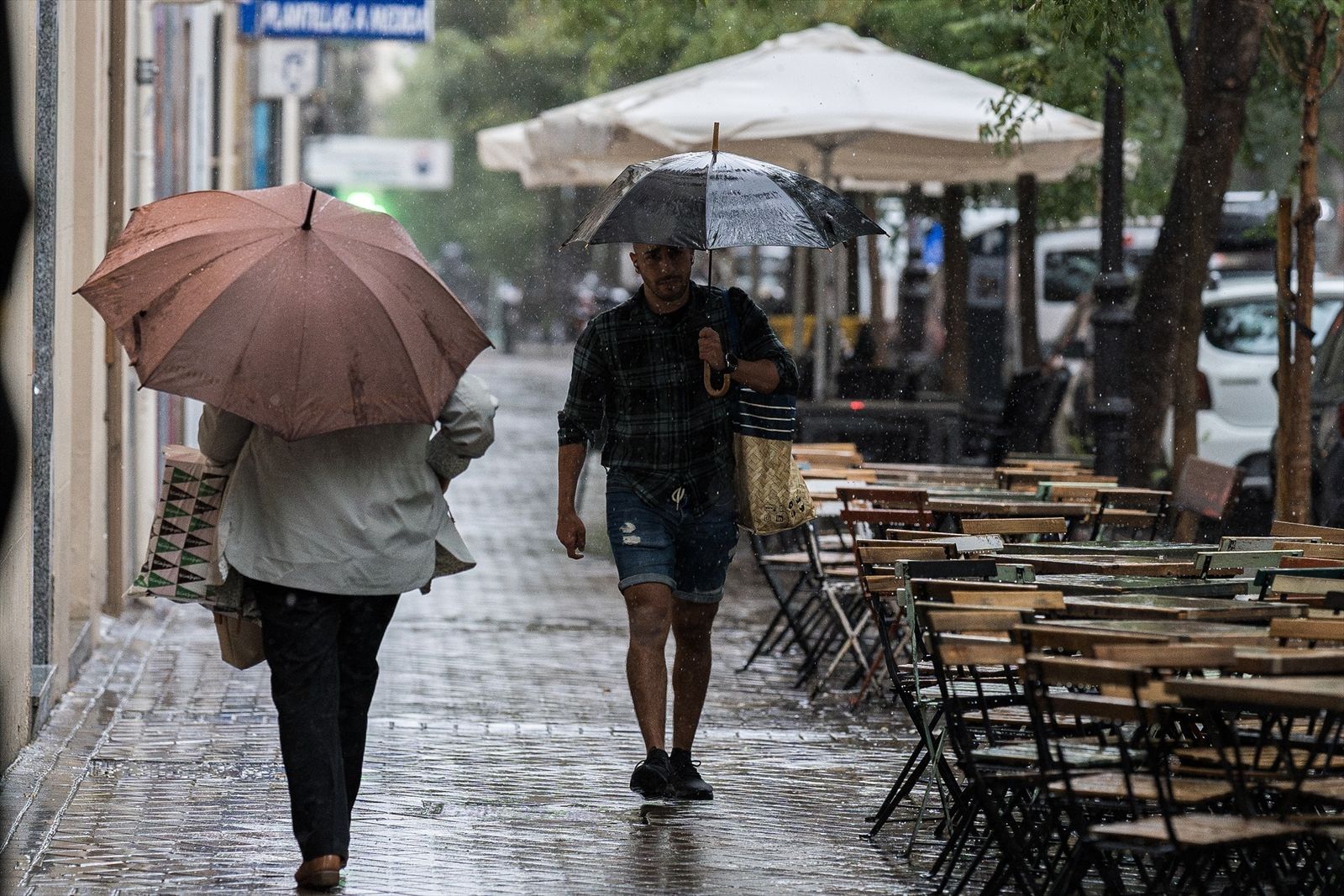 Varias personas se resguardan de la lluvia con paraguas