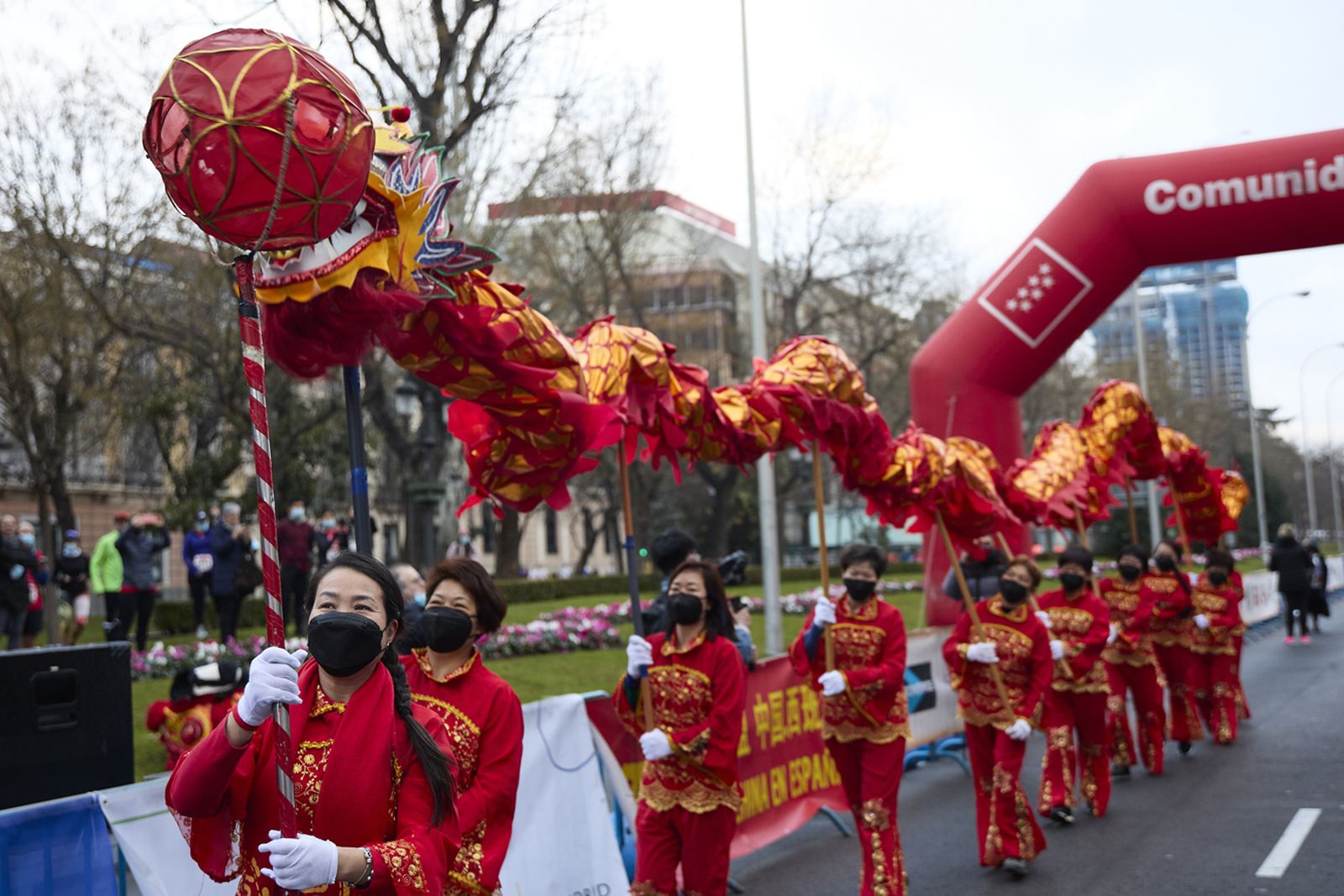 Varias personas realizan la danza del dragón, esencial para celebrar el Año Nuevo Chino, en la carrera de la Primavera 2022