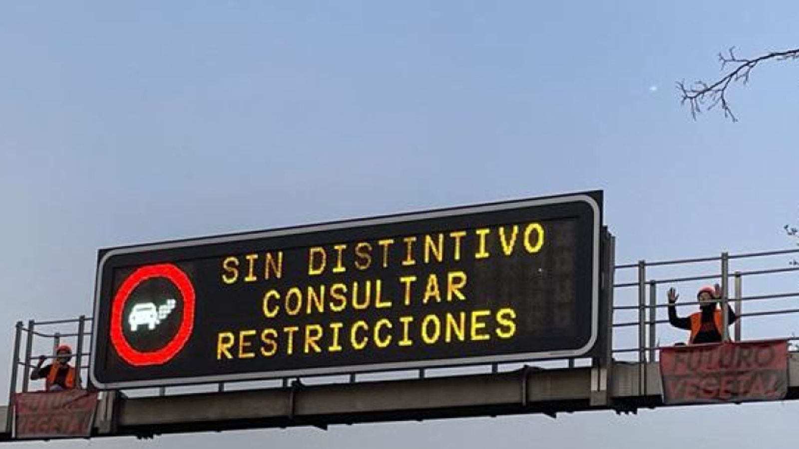 Dos activistas subidas a una señal luminosa