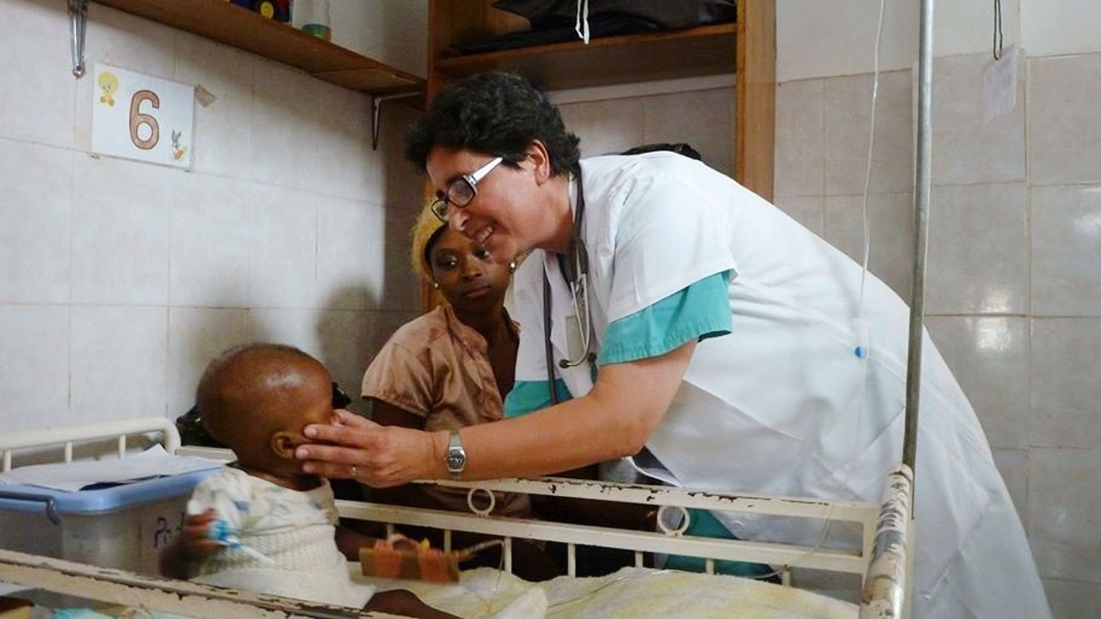 Una sanitaria misionera atiende a un niño en África