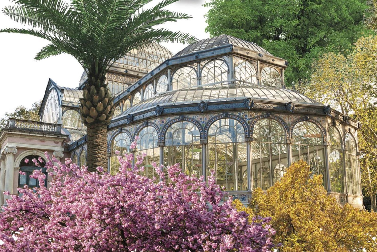 El Palacio de Cristal del Parque del Retiro rodeado de vegetación