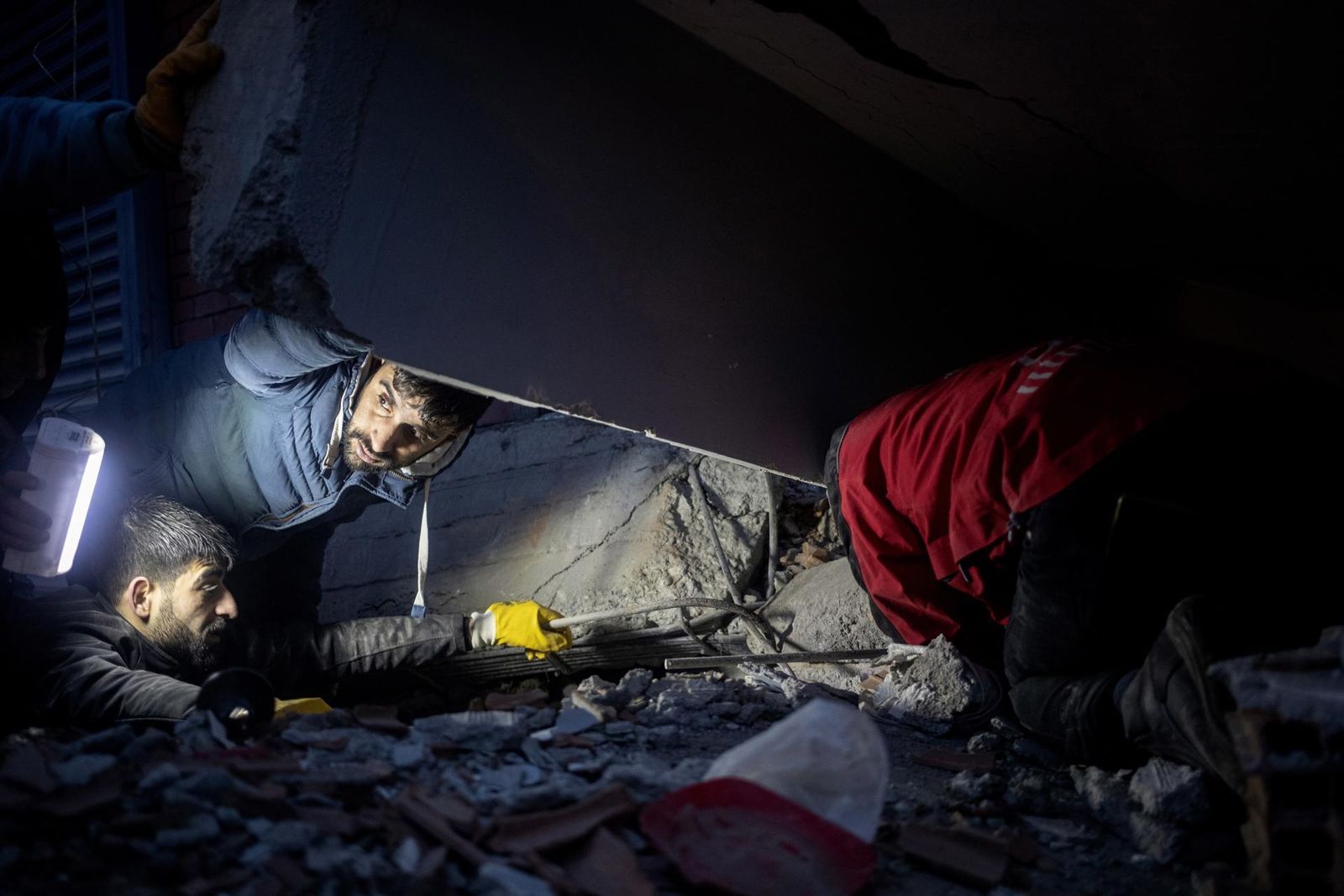 La gente intenta ayudar a personas que han quedado atrapadas en un edificio colapsado
