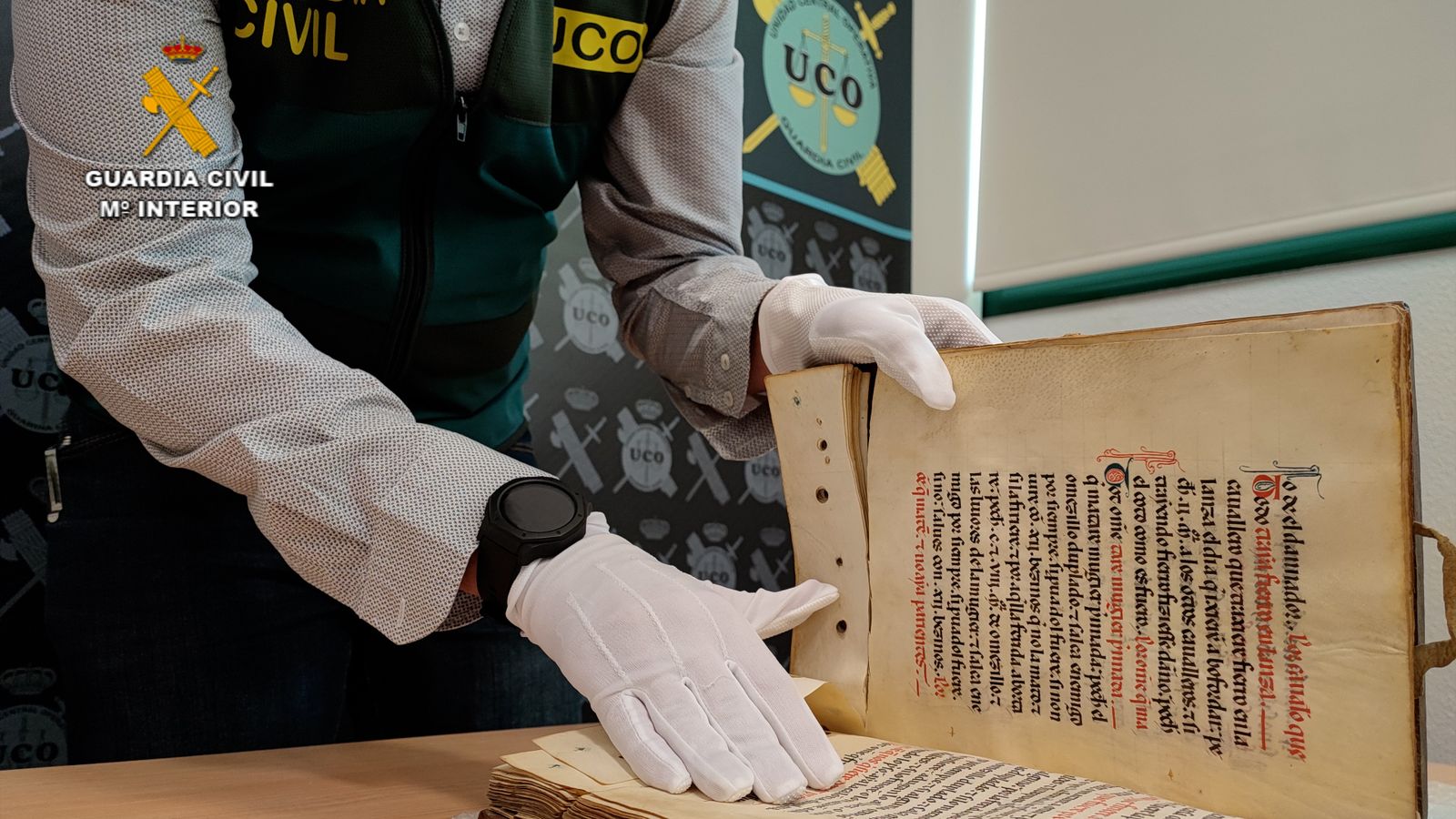 Uno de los agentes de la UCO de la Guardia Civil muestra el volumen recuperado
