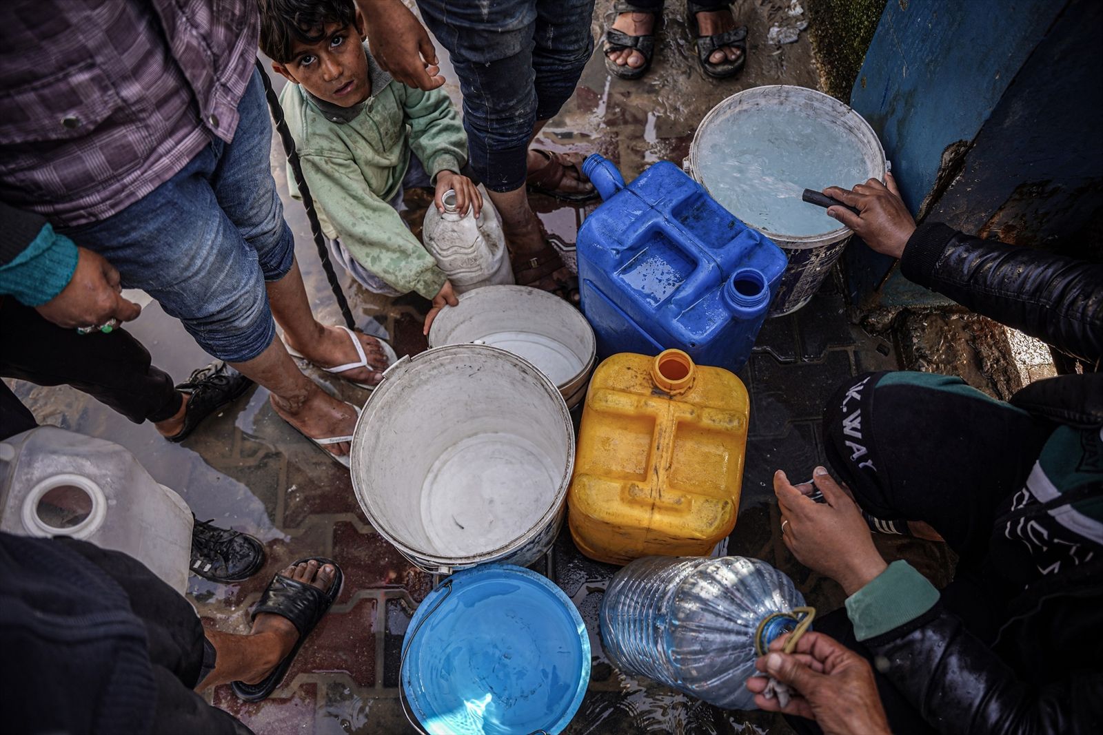 Población palestina de Gaza recoge agua en una estación de servicio