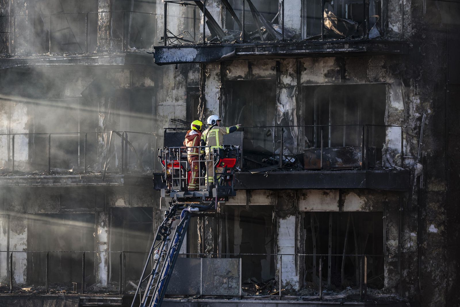 Bomberos inspeccionan el edificio incendiado en Valencia