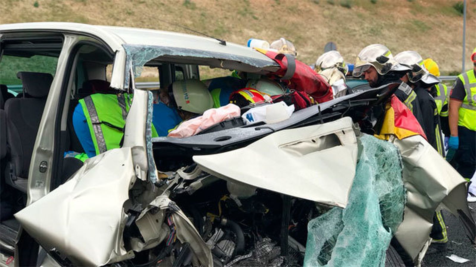 Bomberos y sanitarios en uno de los vehículos siniestrados