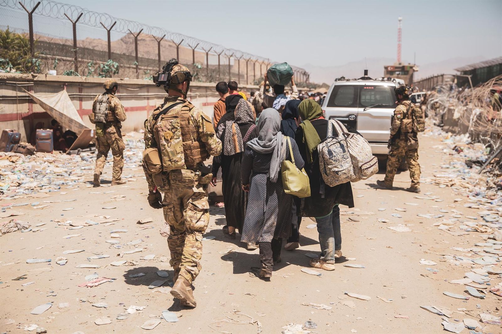 Algunos soldados acompañan a una familia afgana en su evacuación de Kabul