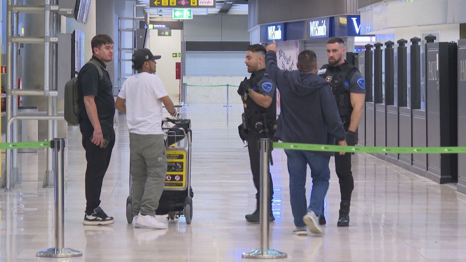 Las personas sin techo se trasladan al parking de la T-4 por los controles para entrar en Barajas