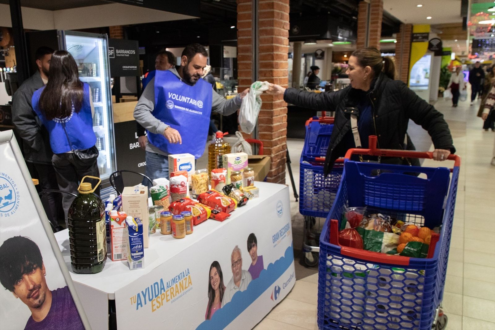 Voluntarios realizando labores de recogida de alimentos, en un supermercado de Alcobendas