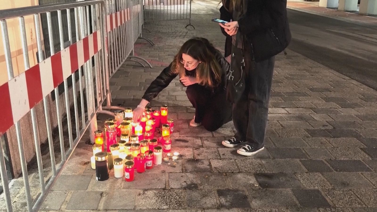 Ciudadanos encienden velas en el lugar del atentado de terrorista cometido en Austria que acabó con la vida de un chico de 14 años y otros cinco heridos