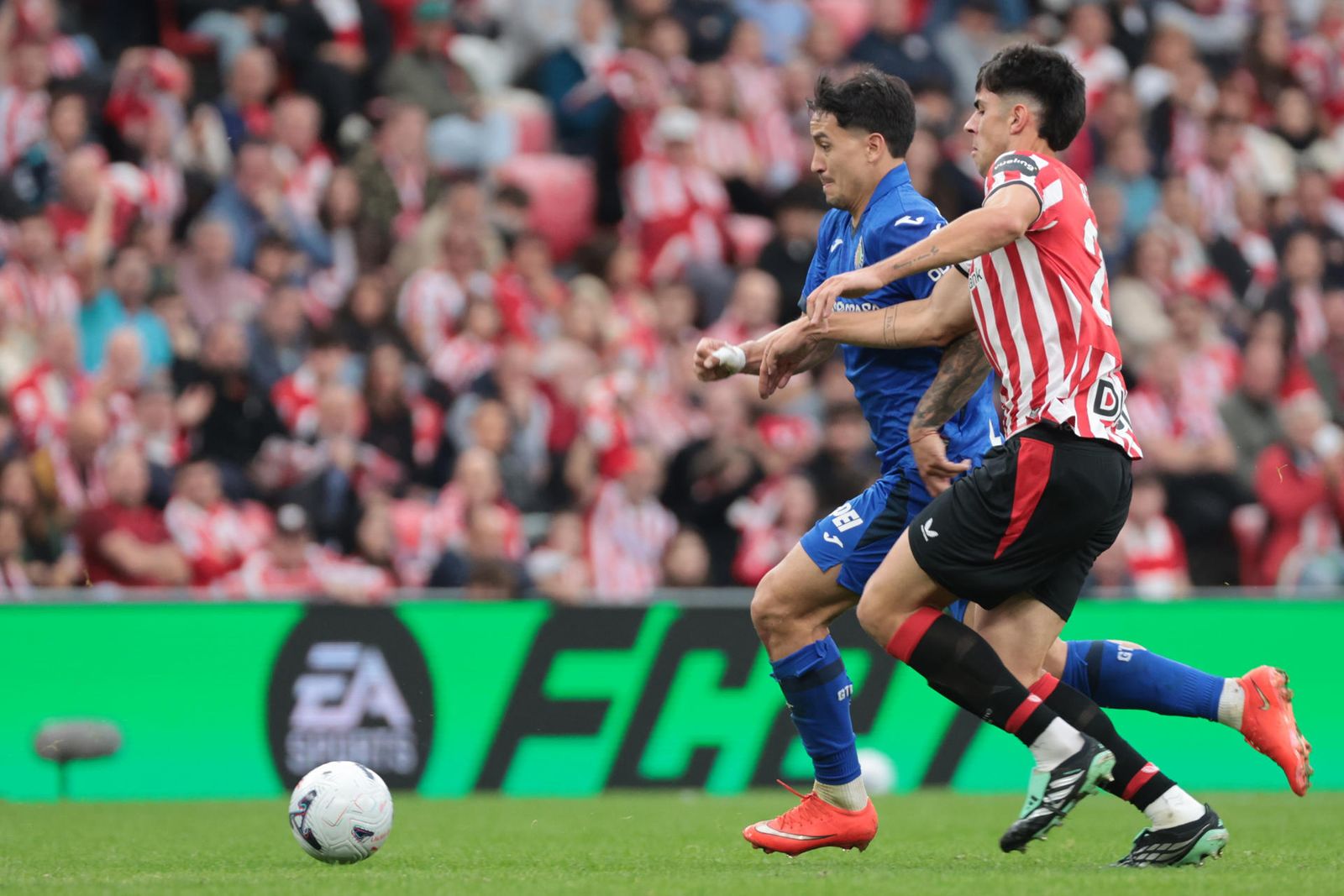 El delantero uruguayo del Getafe Martín Satriano  pelea un balón con el centrocampista del Athletic Beñat Gerenabarrena