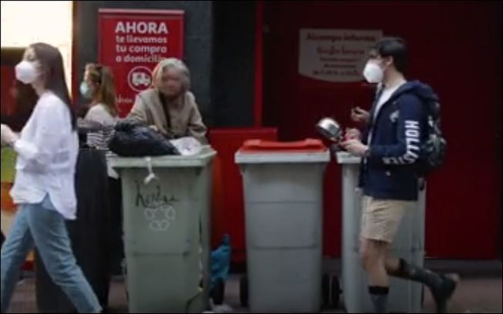 Una anciana busca comida entre la basura en plena cacerolada en Núñez de Balboa