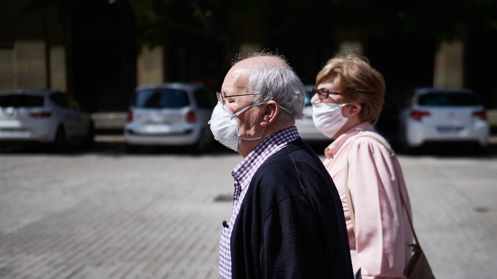 Dos personas mayores caminan por la calle