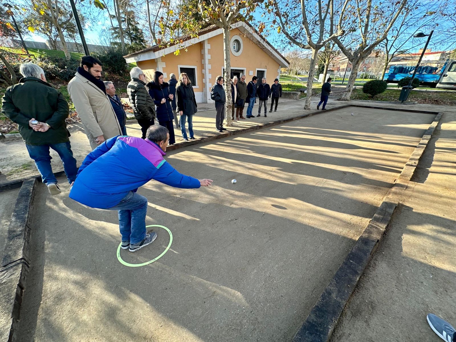 Un hombre lanza las bolas en un juego de petanca