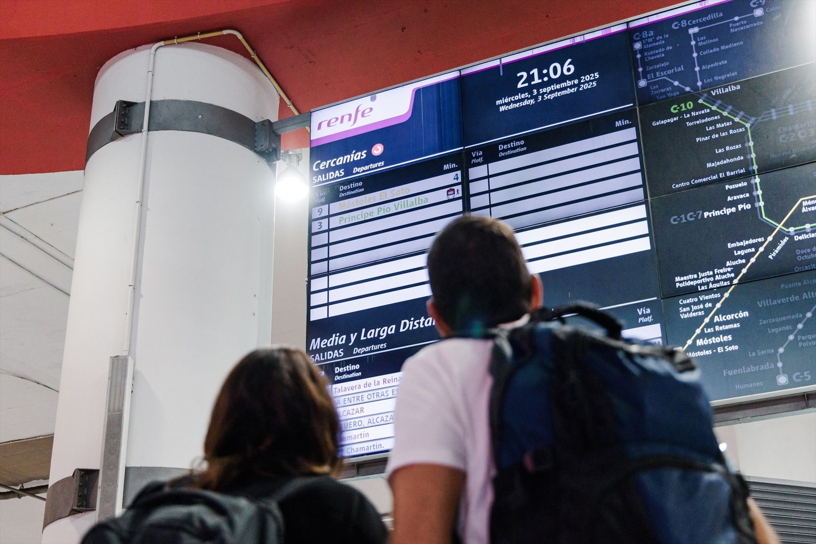 Viajeros observando una pantalla en la estación de Atocha