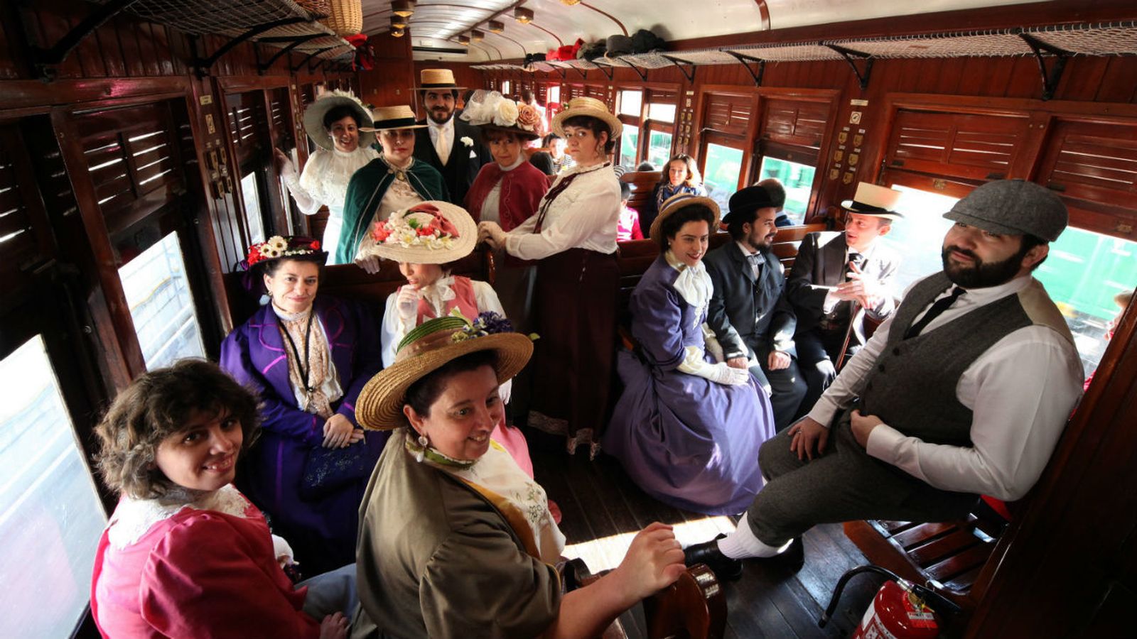 Interior de un coche del Tren de la Fresa con personas ataviadas de época