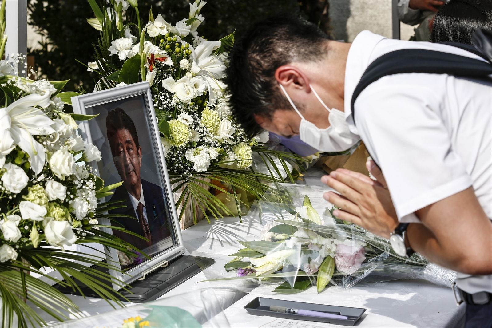 Una persona ofrece una oración silenciosa por el ex primer ministro japonés Shinzo Abe