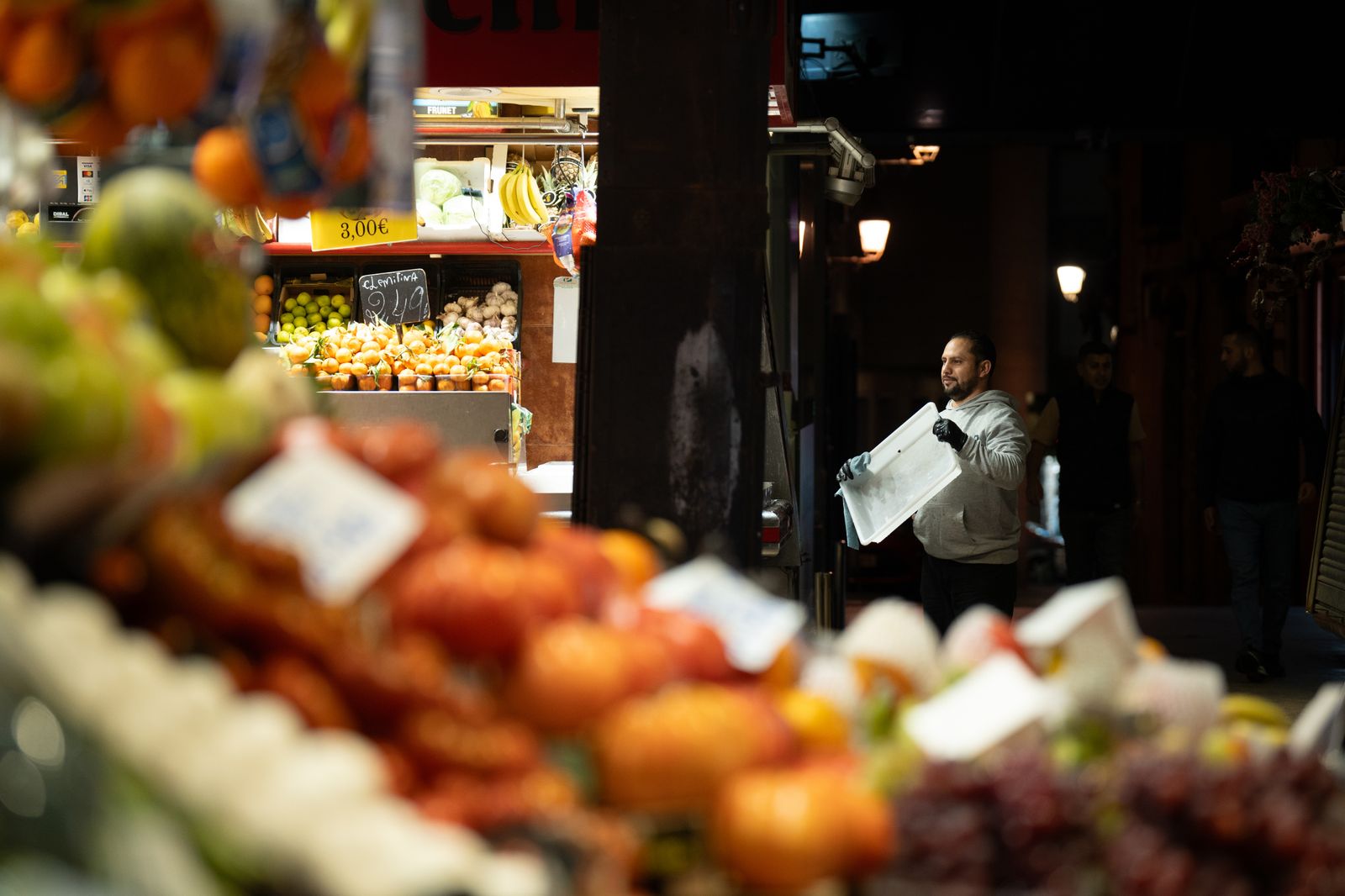 Un comerciante revisa sus productos expuestos, en el Mercado de la Boquería