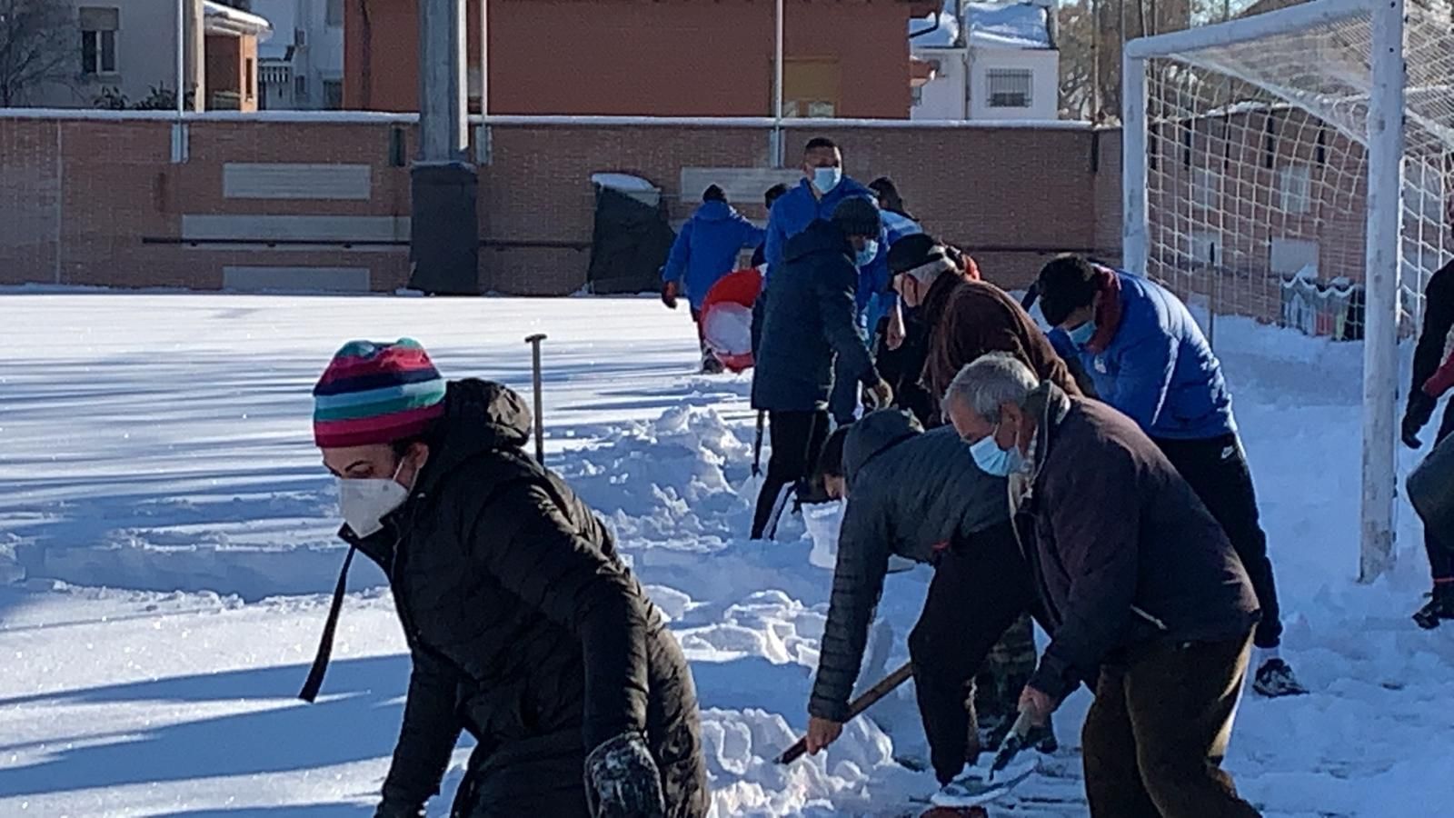 Gente del Navalcarnero limpian la nieve de su estadio