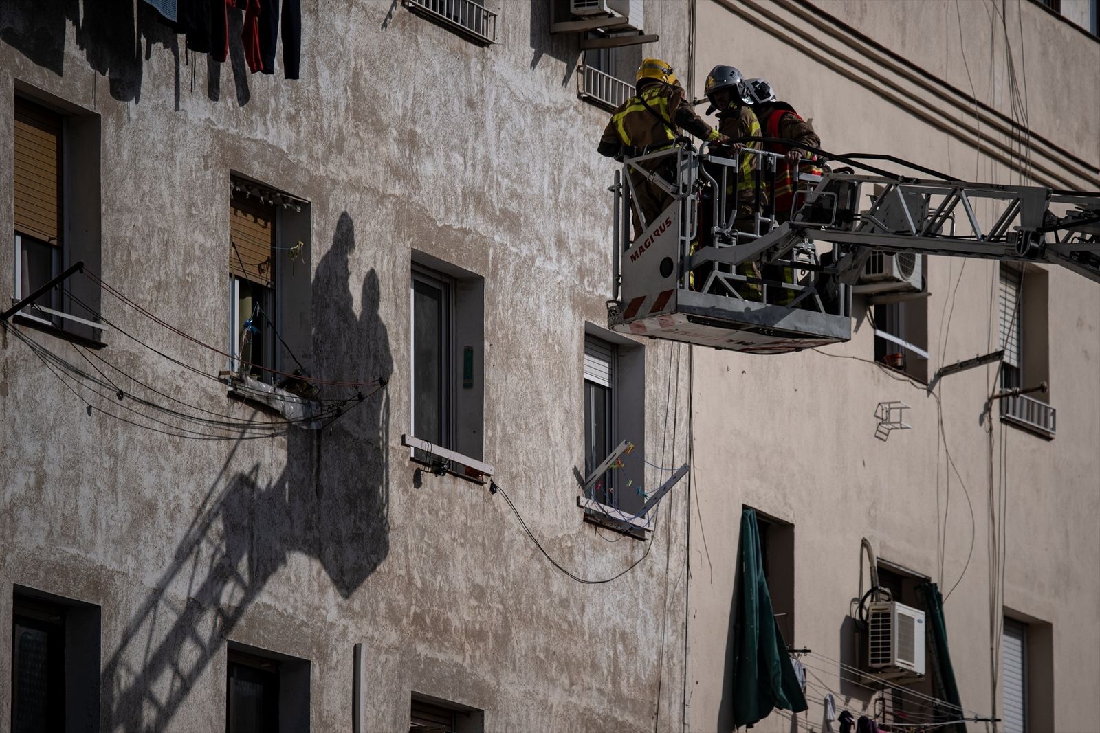 Varios bomberos trabajan en el edificio derrumbado en Badalona