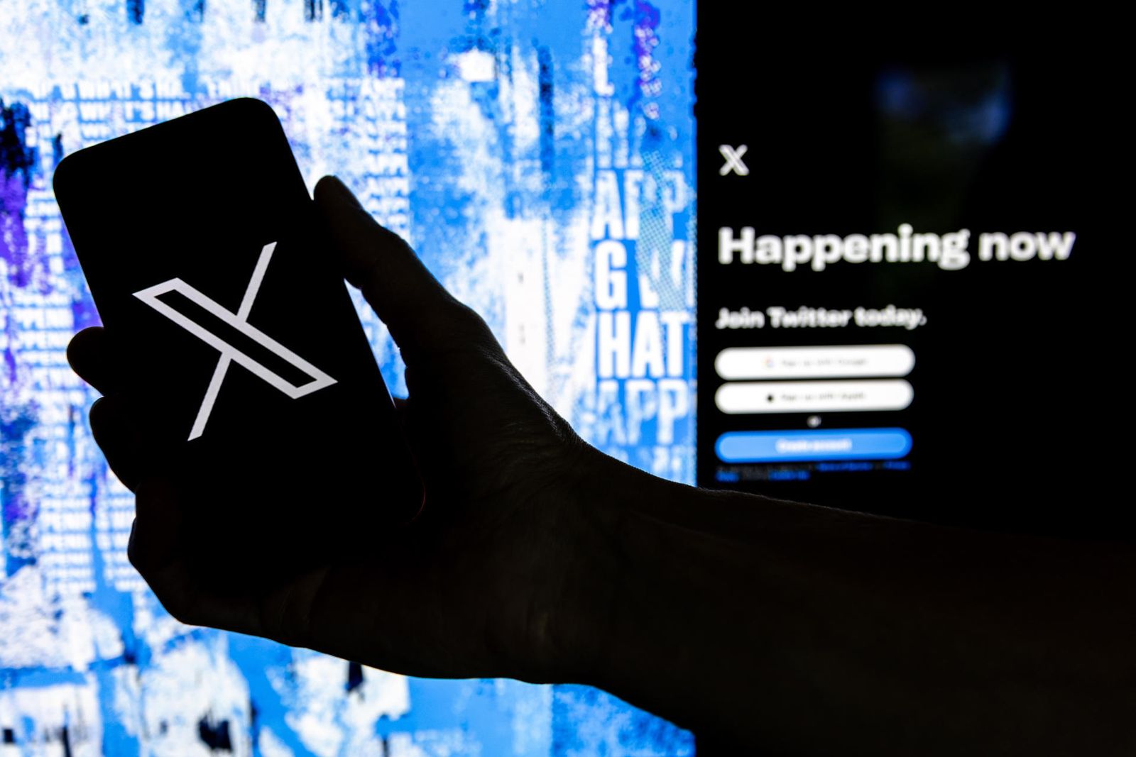 Una persona sostiene un móvil con el logo de X