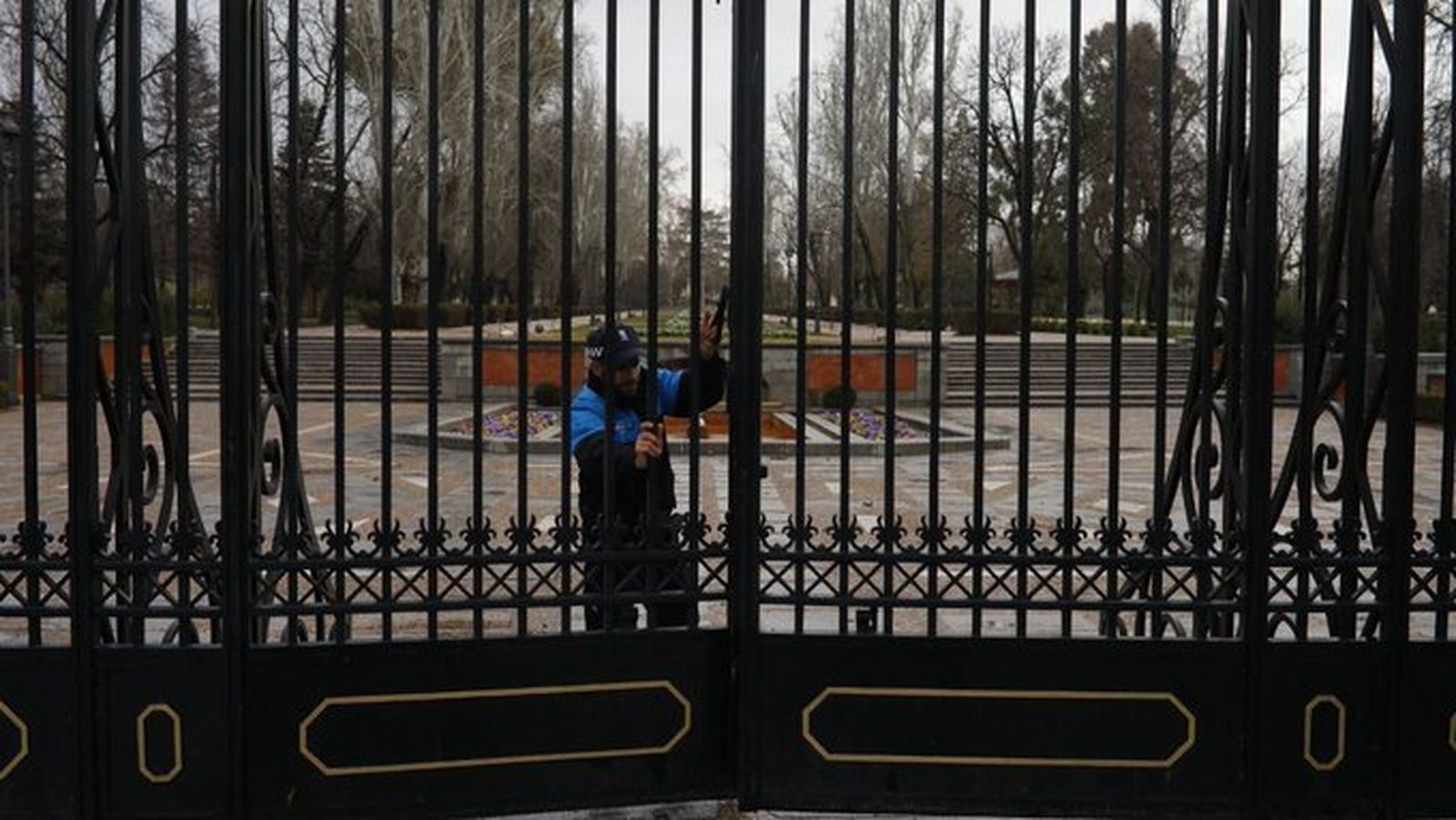 Un agente municipal cierra el Parque del Retiro