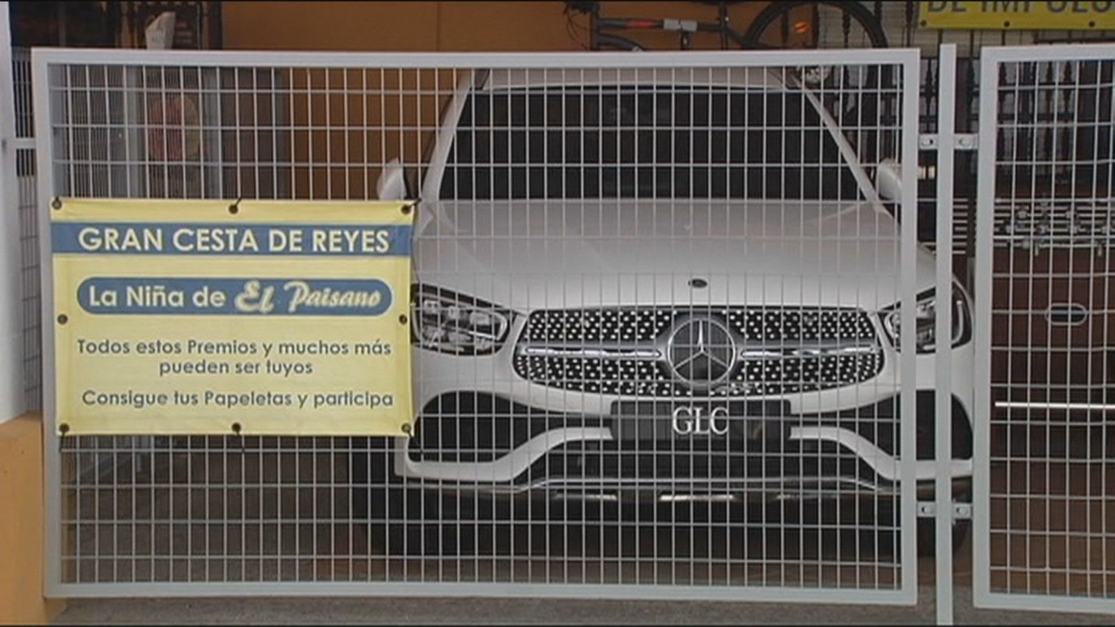 Una cesta de Navidad con un piso, un coche, una moto y un medicamento para los gases
