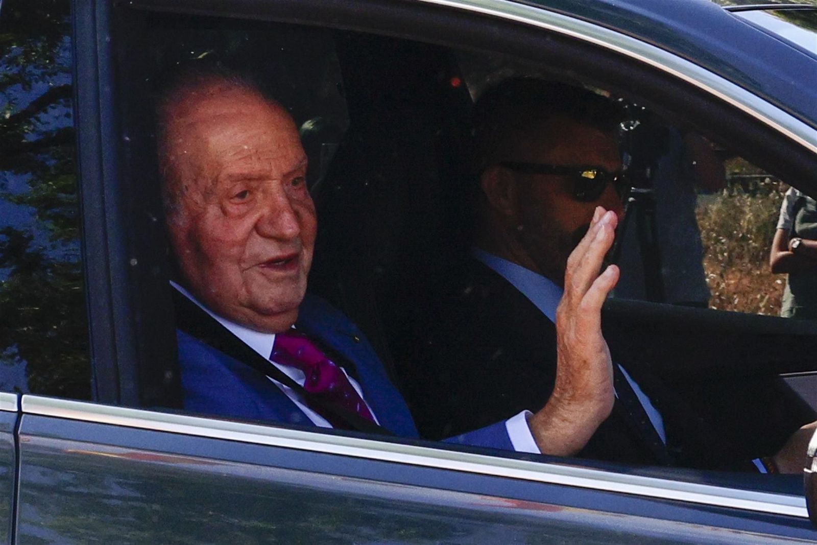 Recibimiento a Juan Carlos I en Zarzuela con banderas españolas y gritos de "¡Viva el rey!"