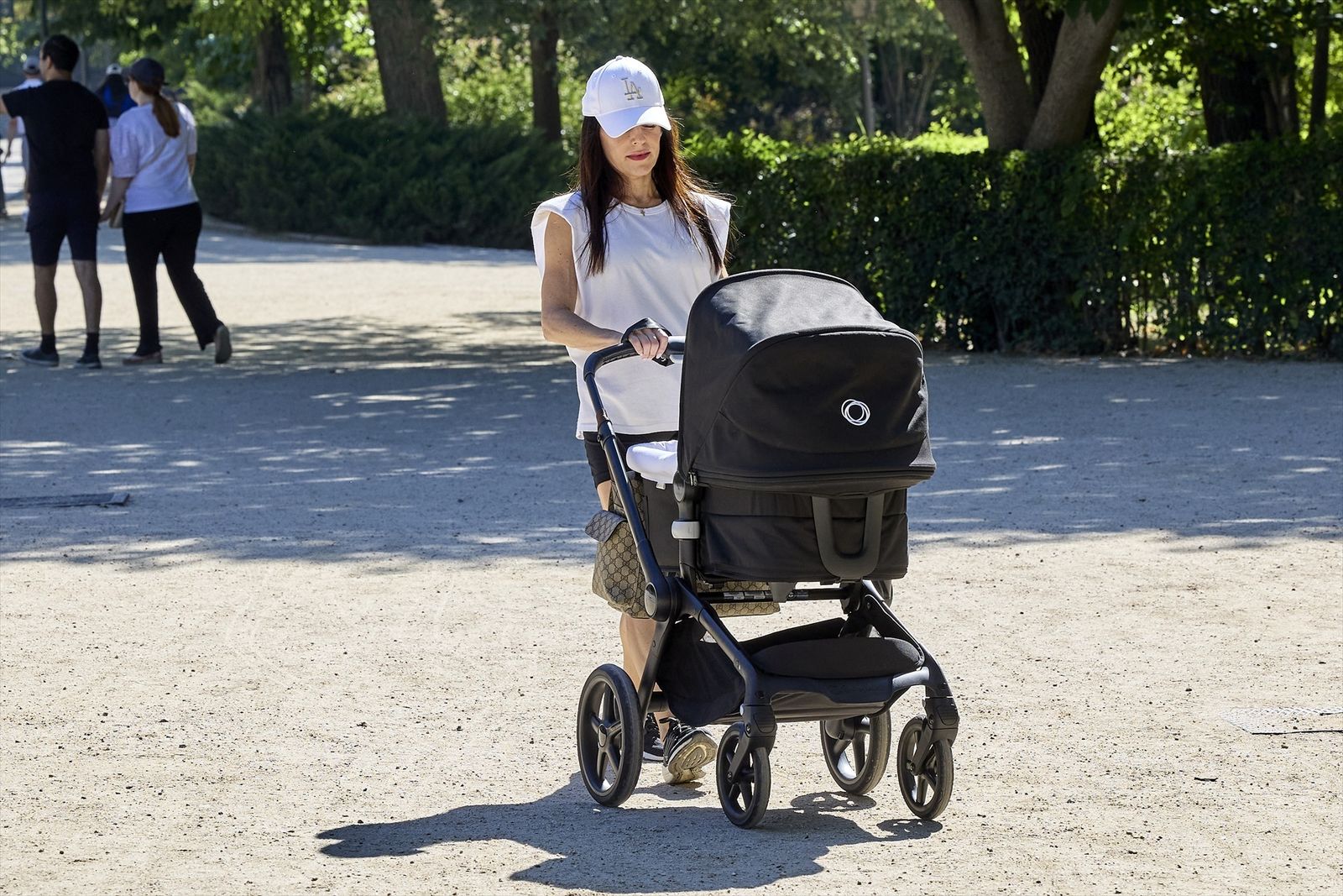 Una madre pasea con su bebé en el parque de El Retiro