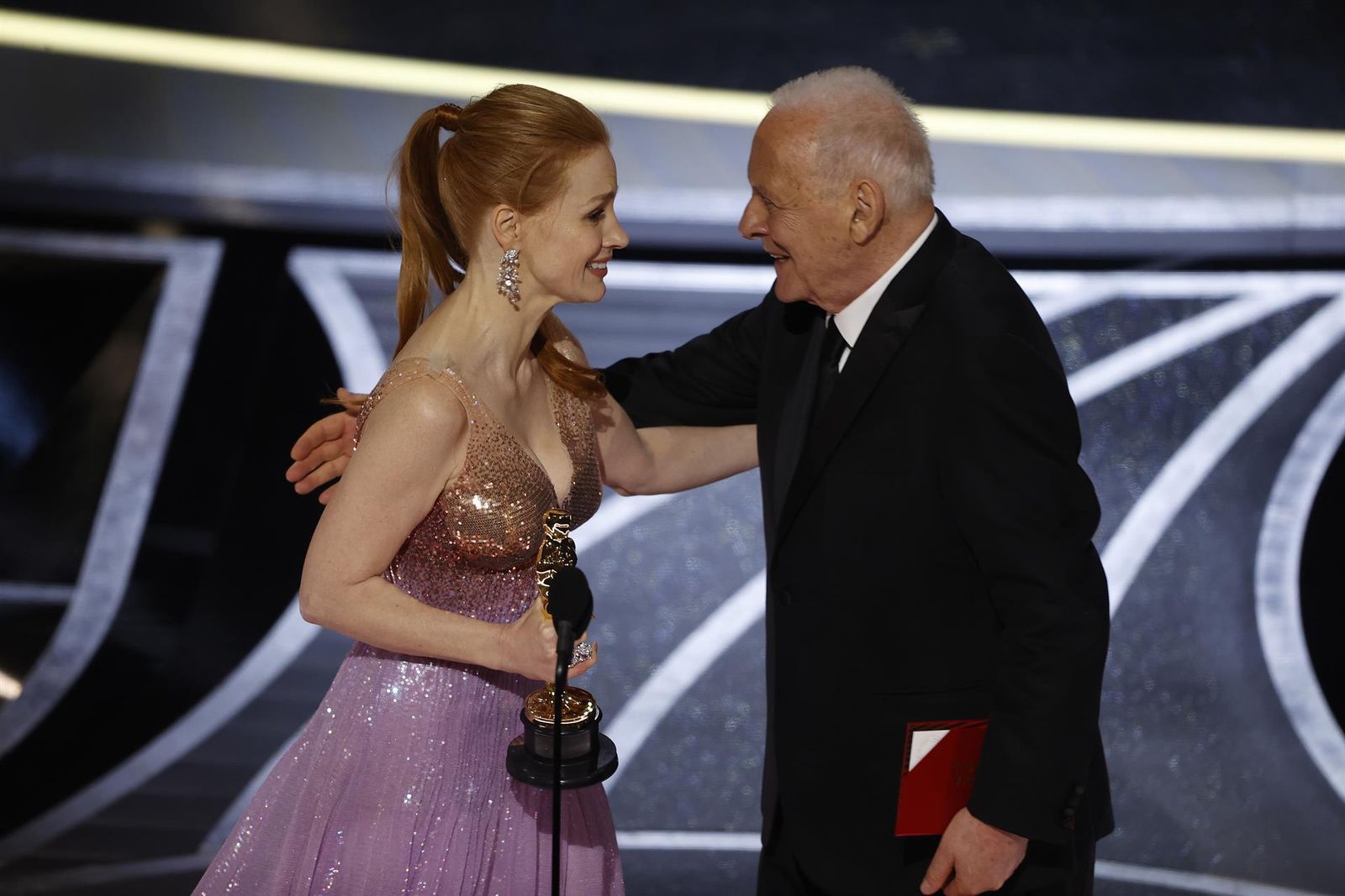 El actor británico Sir Anthony Hopkins presenta a la actriz estadounidense Jessica Chastain con el Oscar a la mejor actriz por 'Los ojos de Tammy Faye' durante la 94ª ceremonia anual de los Premios de la Academia en el Dolby Theatre de Hollywood.