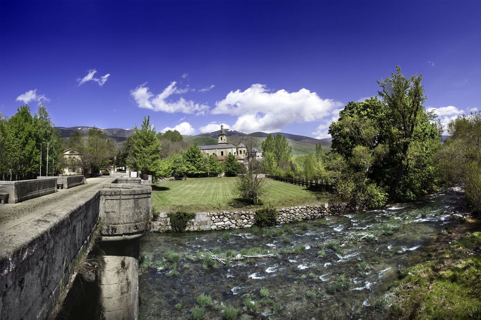 Vista del Puente del Perdón, la Cartuja de El Paular y las montañas de la Sierra de Guadarrama