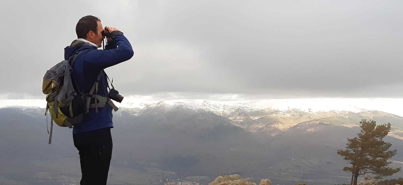 Una persona observa aves en la Sierra de Guadarrama