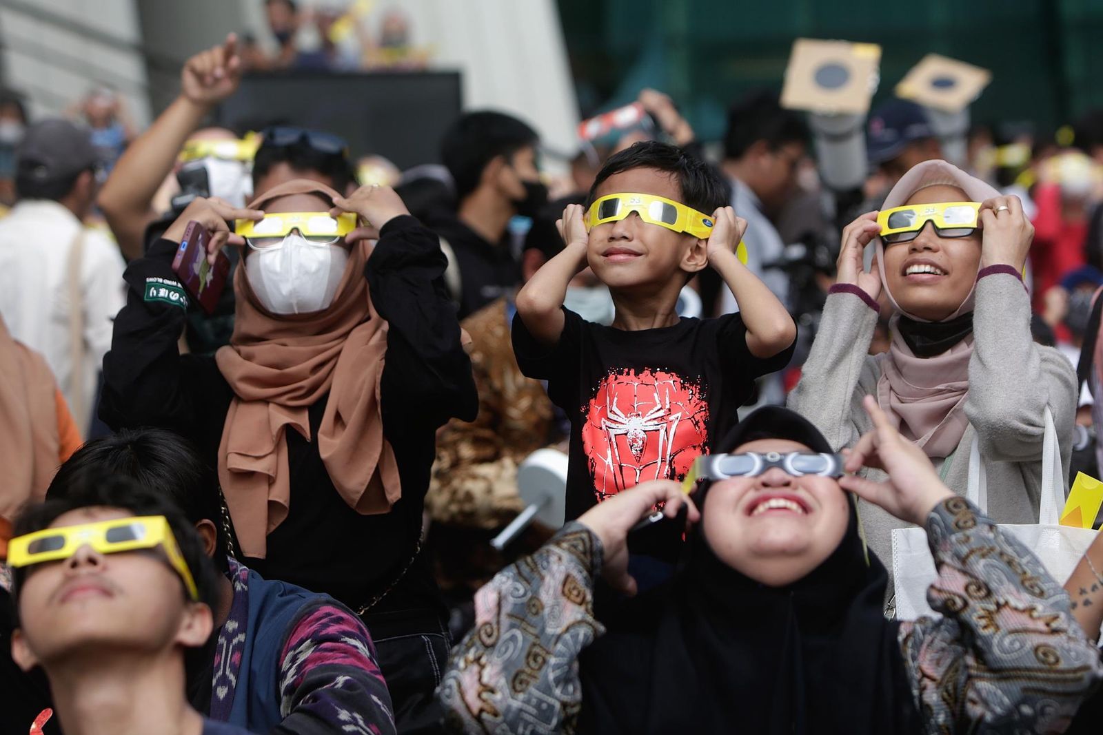 Personas en Yakarta contemplando el eclipse solar híbrido