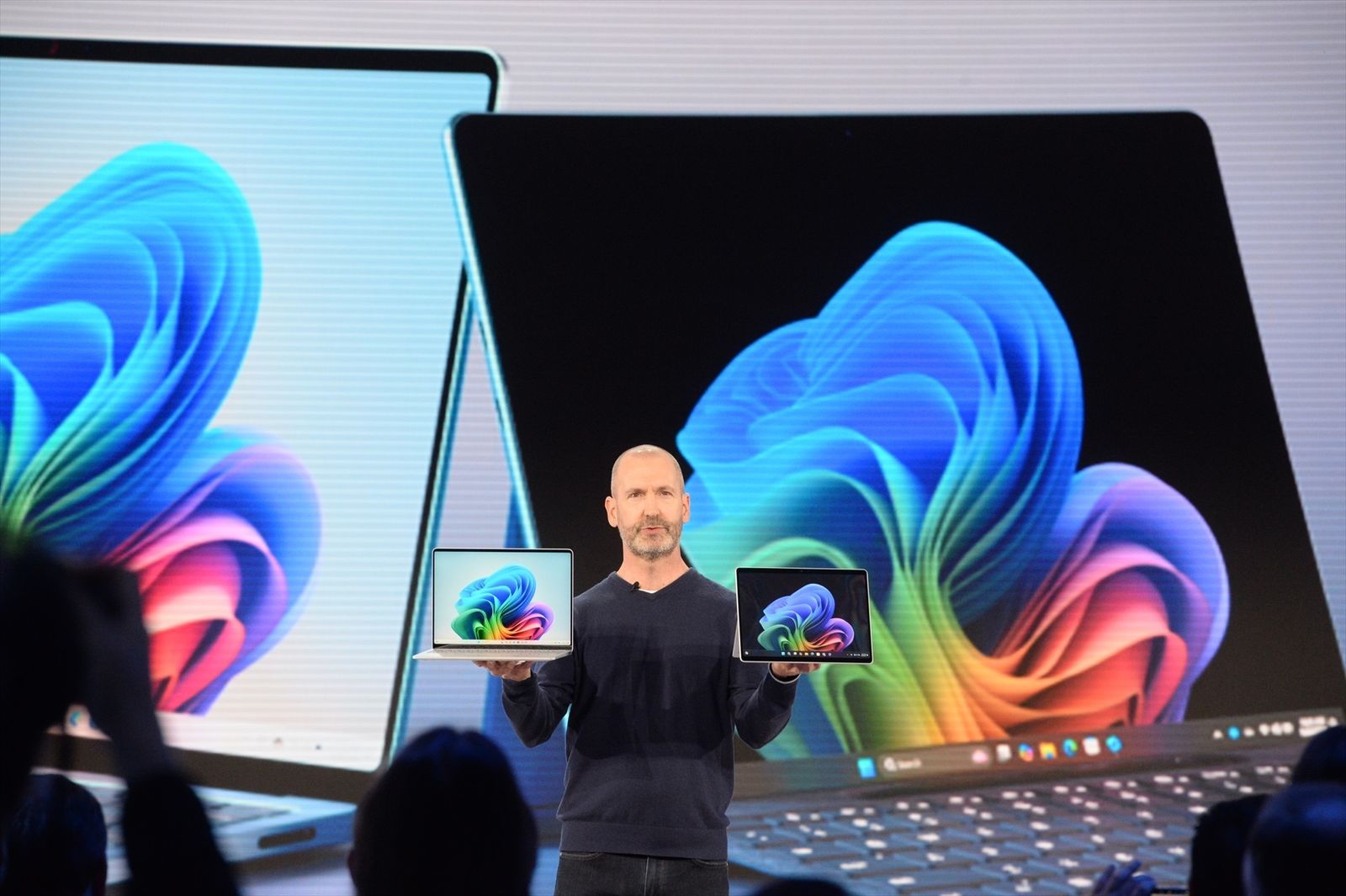 Brett Ostrum muestra un portátil y una tableta de la marca Surface, diseñados para su uso con IA