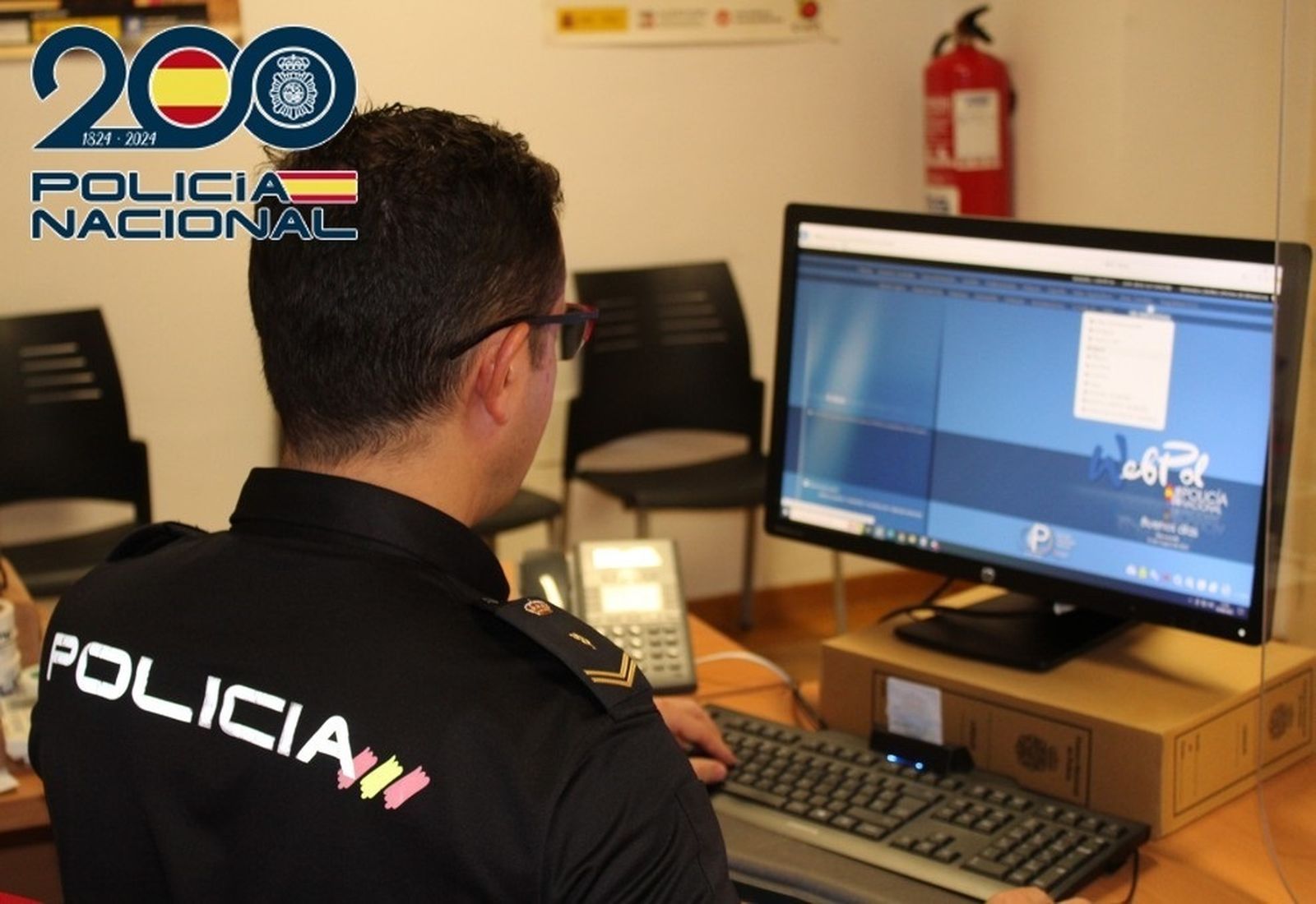 Un policía nacional con un ordenador