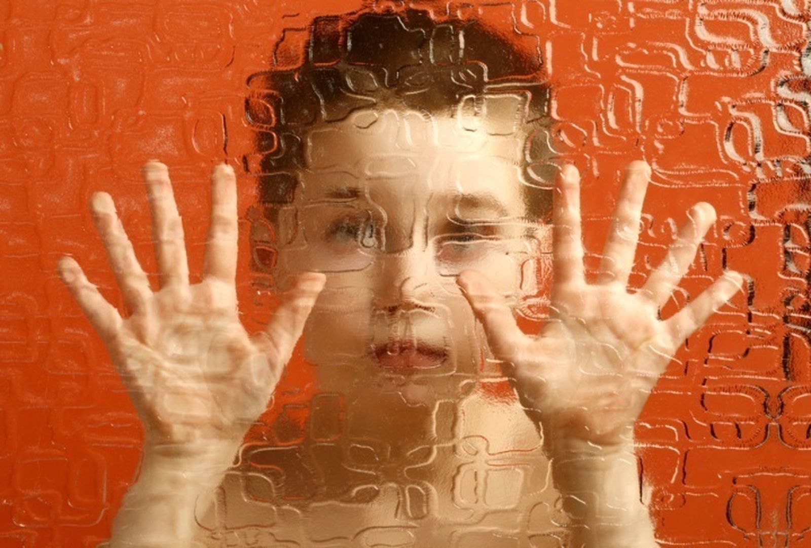 Un niño mira a través de un cristal