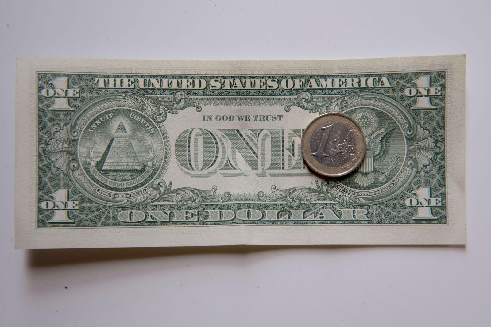 Una moneda de euro y un billete de dólar