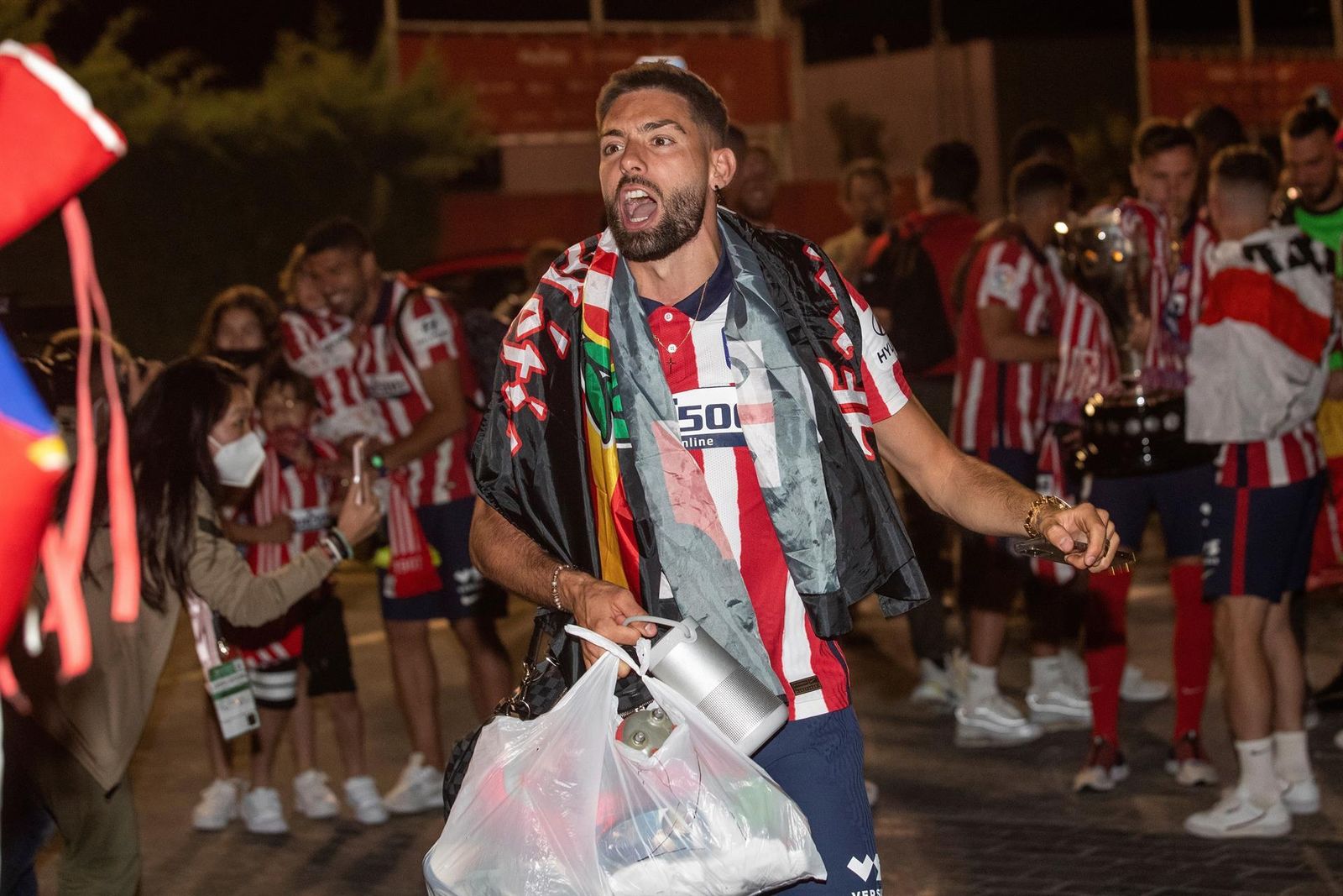 El jugador belga del Atlético de Madrid Yannick Carrasco celebra con la afición a su llegada esta noche a la Ciudad deportiva Wanda