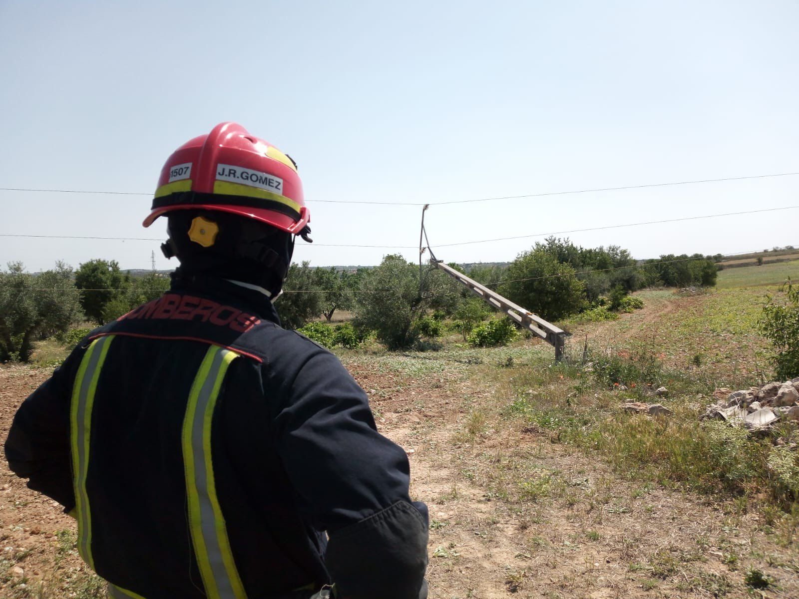 Un bombero cerca del poste de alta tensión caído sobre el olivo,  en Villarejo de Salvanés
