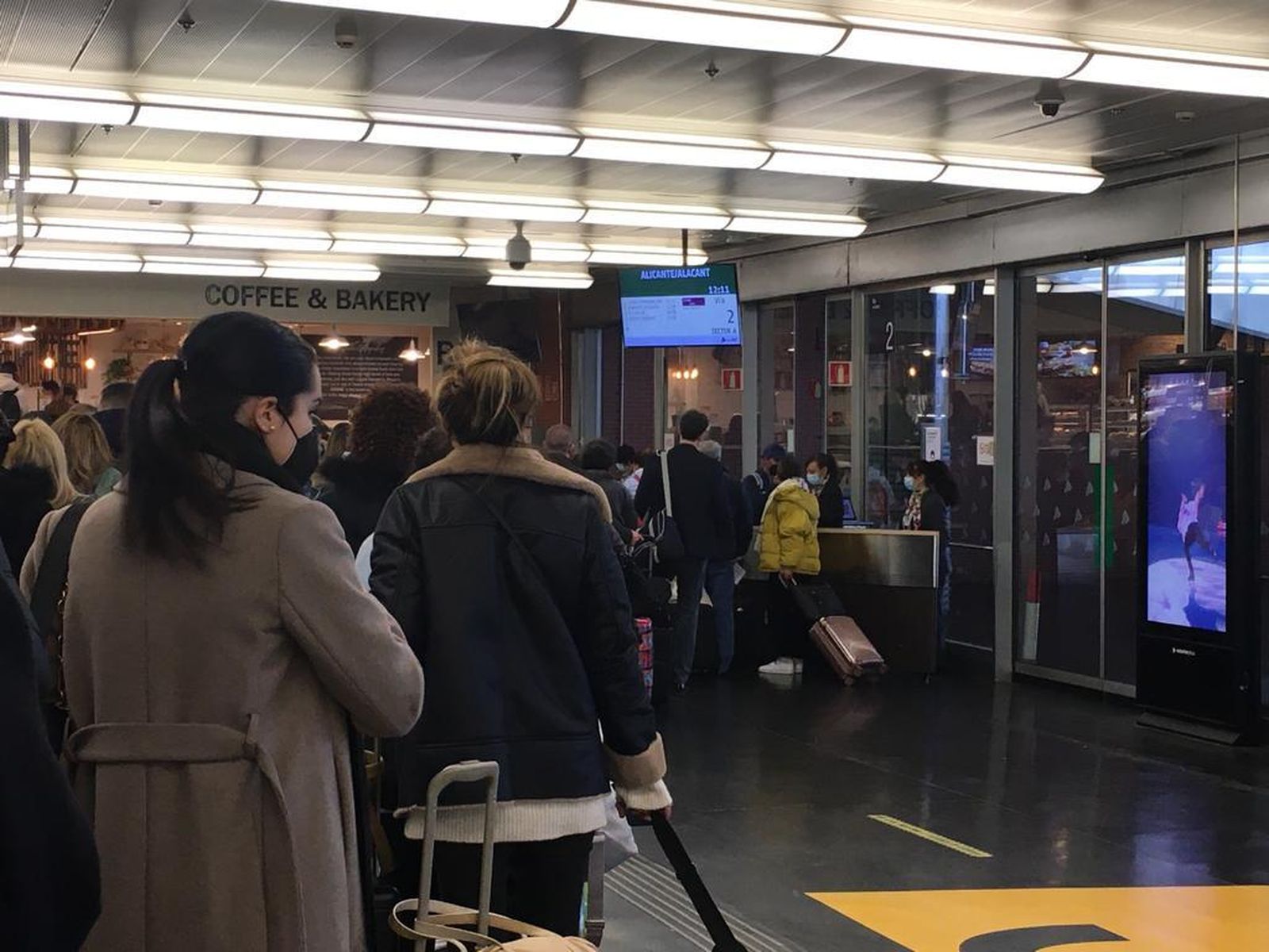 Personas esperando embarcar en un Ave destino Alicante en la estación de Atocha