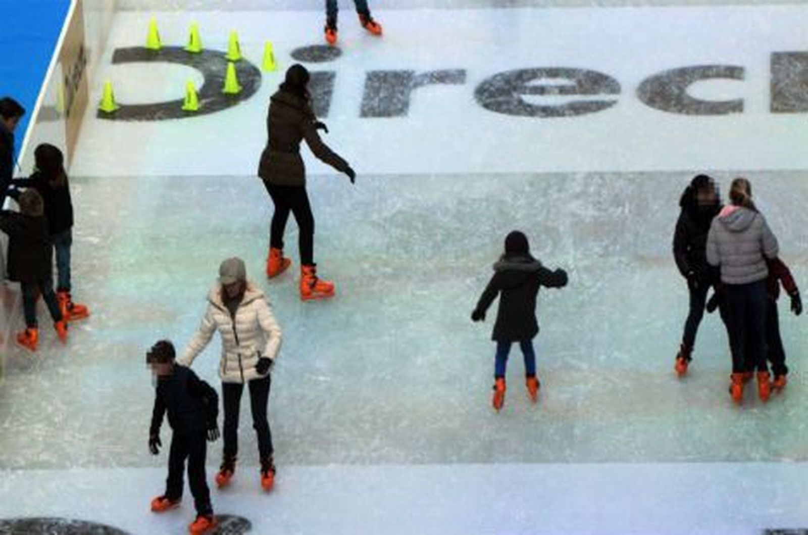 Los madrileños disfrutan de la pista de hielo del palacio de Cibeles