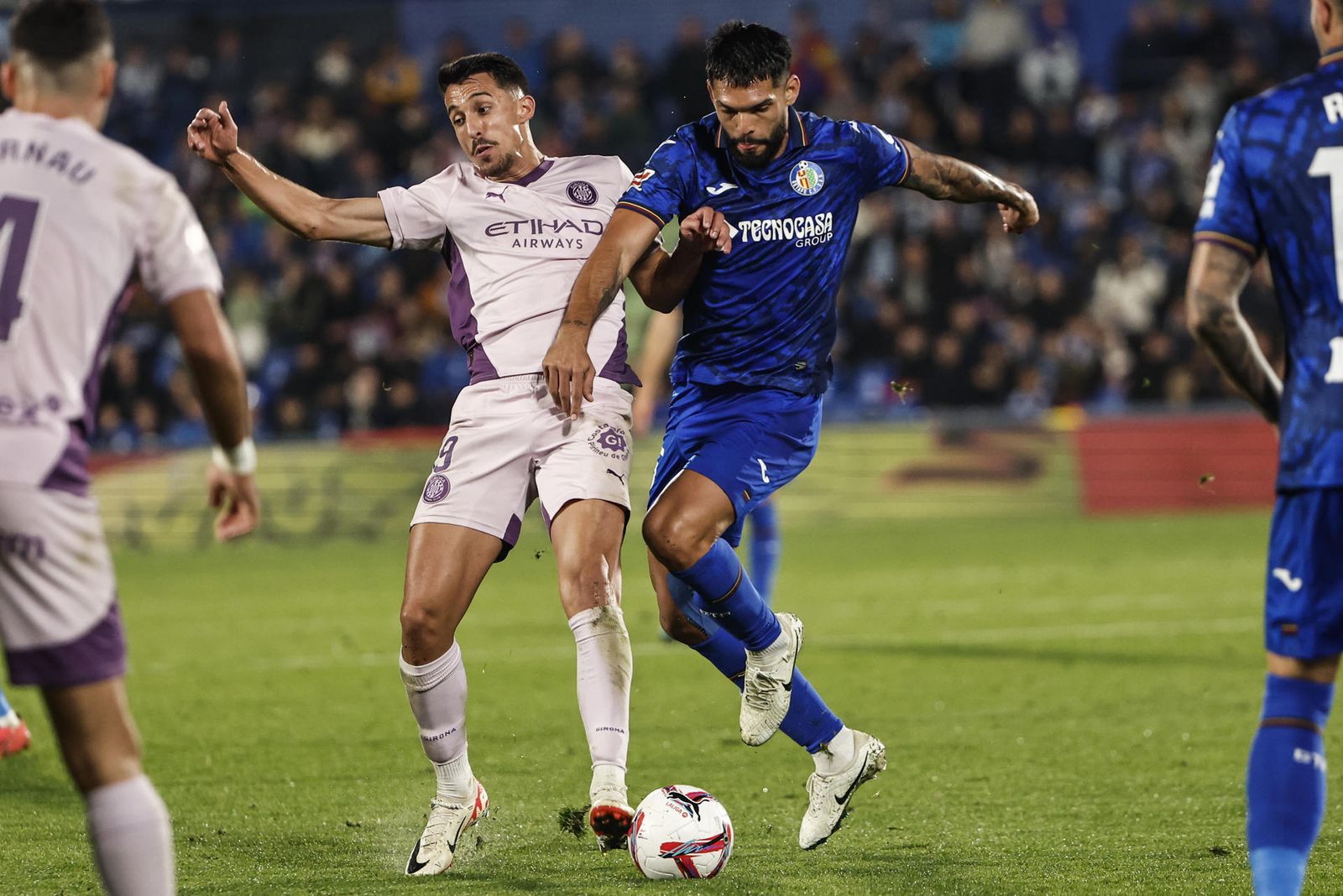 El defensa del Getafe Omar Alderete juega un balón ante Bojan Miovski, del Girona