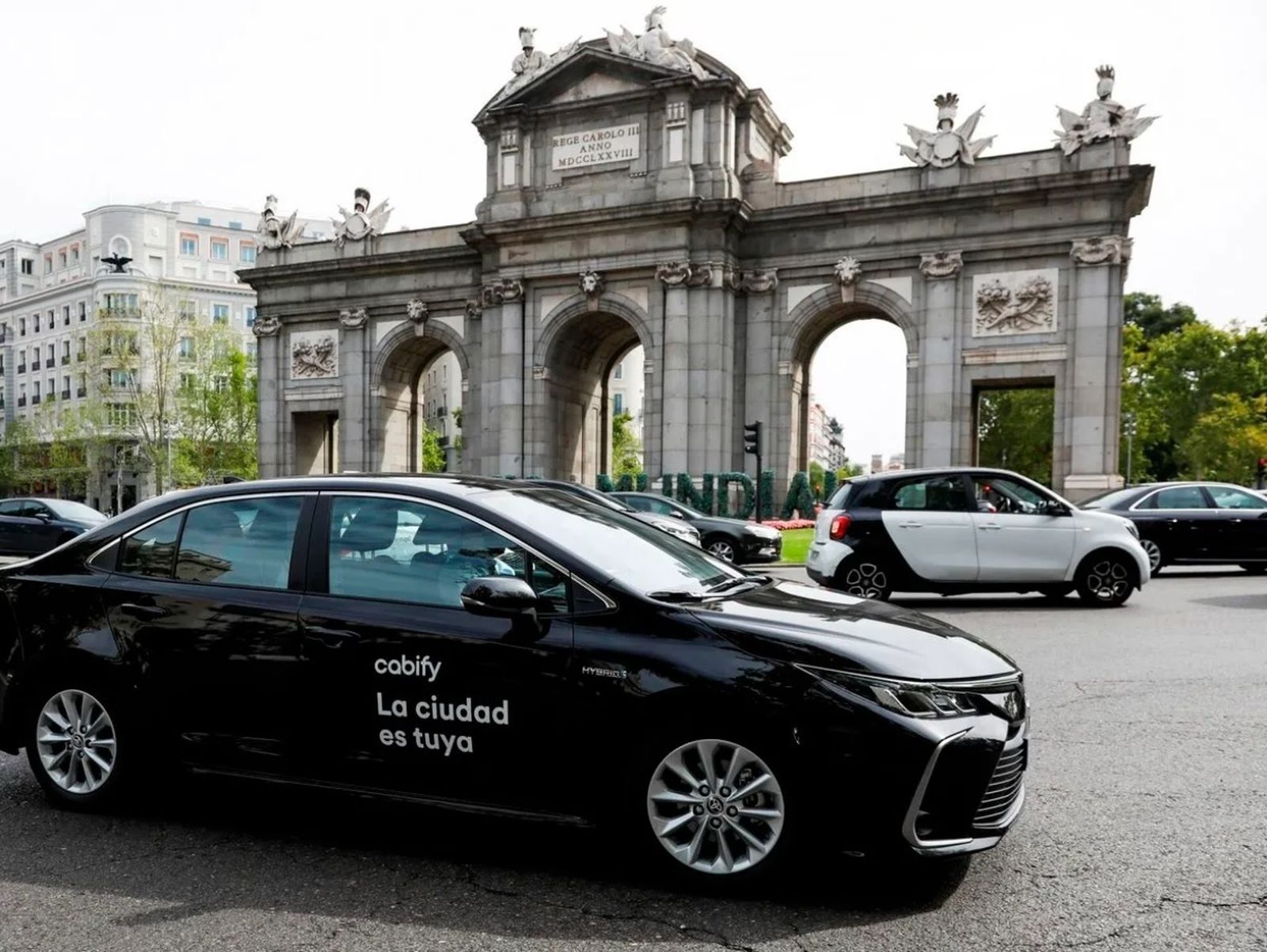 Un VTC frente a la Puerta de Alcalá de Madrid