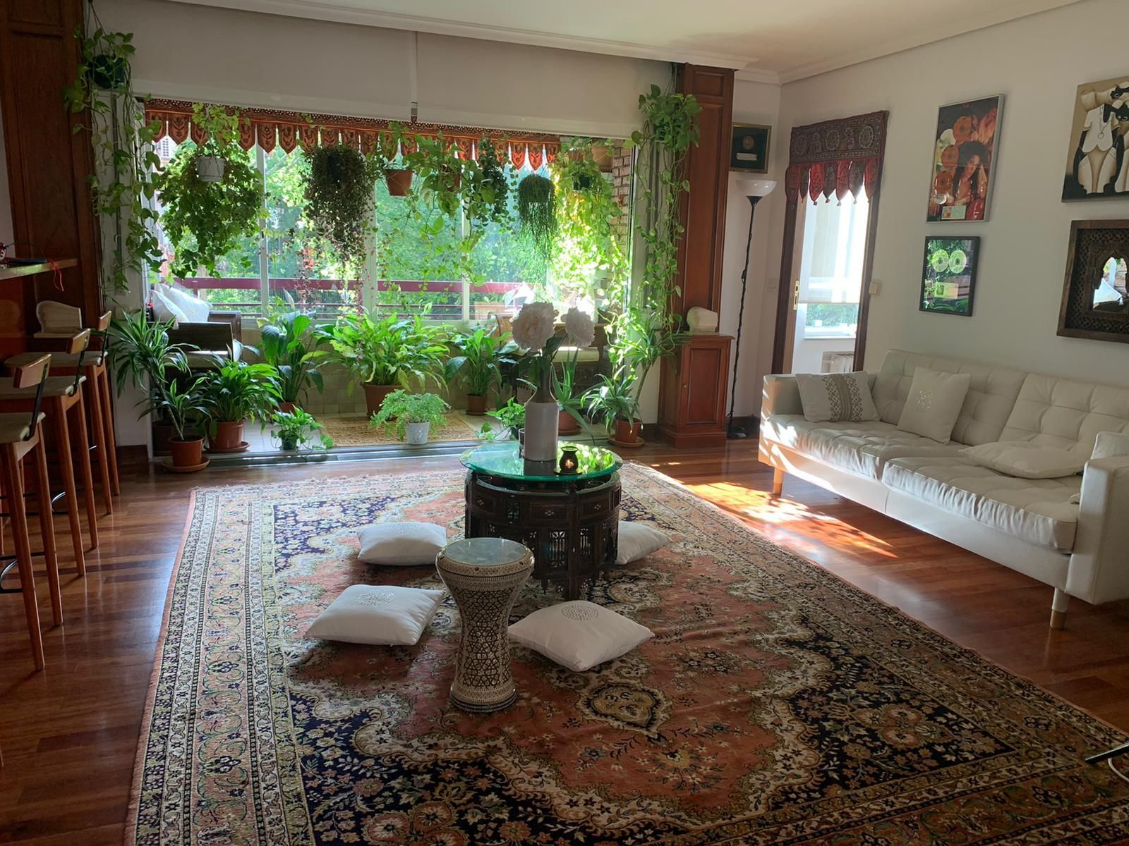 La vivienda de la cantante Cristina del Valle nos traslada al mundo árabe. Alfombras persas, cojines en el suelo y plantas, muchas plantas junto a los grandes ventanales.
